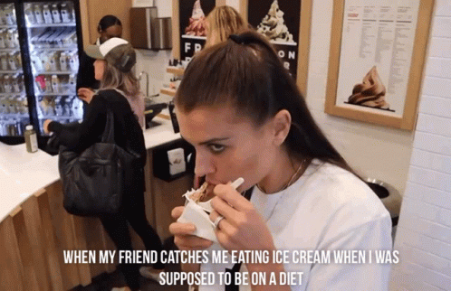 A Woman Eating Ice Cream In Front Of A Sign That Says Fr GIF