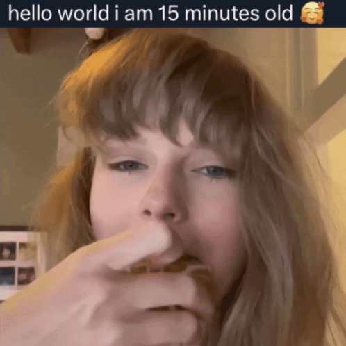 A Woman Eating Something With The Words Hello World I Am 15 Minutes Old On The Bottom GIF