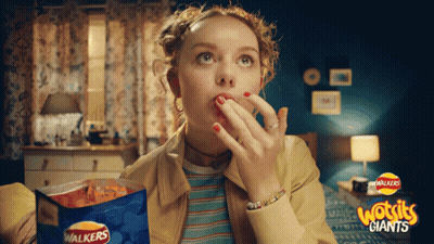 A Woman Eating Walkers Giants Chips In A Room GIF