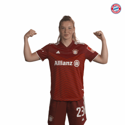 A Woman Flexes Her Muscles Wearing A Red Allianz Jersey GIF