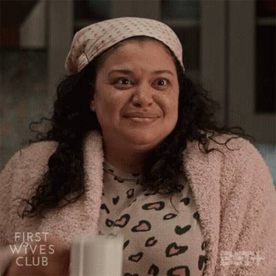 A Woman From The First Wives Club Is Smiling And Wearing A Leopard Print Shirt GIF