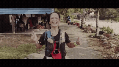 A Woman Giving A Thumbs Up While Wearing A Backpack With The Word Buff On It GIF