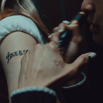 A Woman Has A Tattoo On Her Arm That Says Love & E GIF
