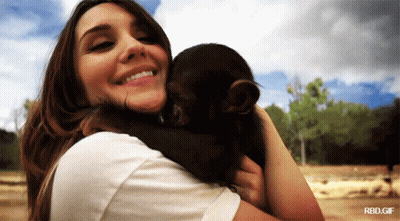 A Woman Holding A Baby Monkey With A Rbd.gif Watermark GIF