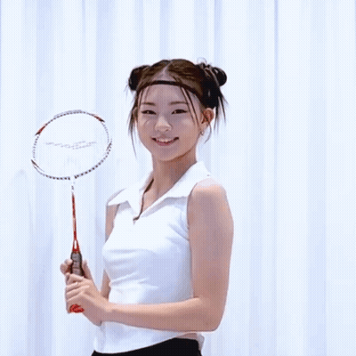 A Woman Holding A Badminton Racket With The Word Slazenger On The Handle GIF
