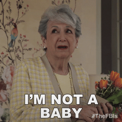 A Woman Holding A Bouquet Of Flowers Says " I 'M Not A Baby " GIF