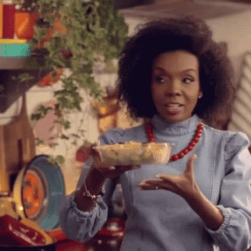 A Woman Holding A Bowl Of Food In Her Hand GIF