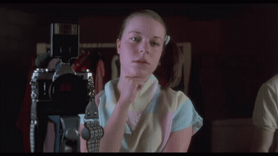 A Woman Holding A Camera With The Words " This Is Looking Really Good " Above Her GIF