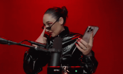 A Woman Holding A Cell Phone In Front Of A Microphone With The Word Obstacle On The Bottom GIF