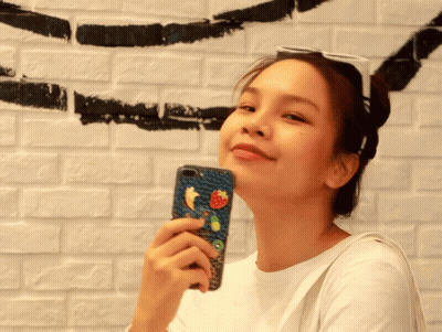 A Woman Holding A Cell Phone With A Strawberry And Kiwi On It GIF