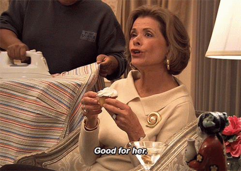 A Woman Holding A Cupcake With The Words Good For Her Above Her GIF