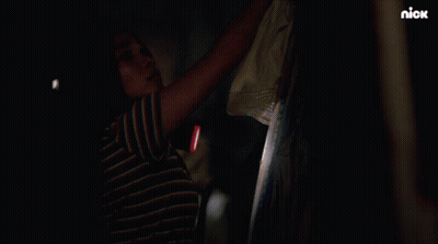 A Woman Holding A Flashlight In A Dark Room With A Nick Logo On The Bottom GIF