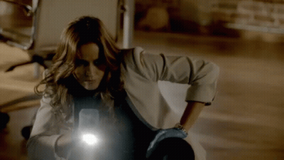 A Woman Holding A Flashlight In Her Hand GIF
