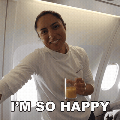 A Woman Holding A Glass Of Orange Juice With The Words I 'M So Happy On The Bottom GIF