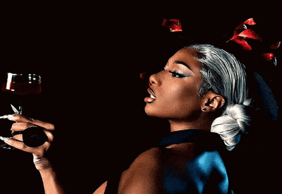 A Woman Holding A Glass Of Red Wine In Her Hand GIF