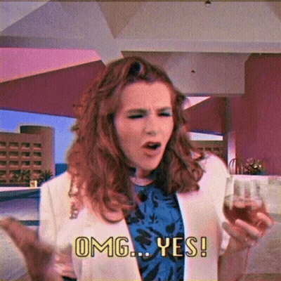 A Woman Holding A Glass Of Wine And Saying Omg Yes GIF