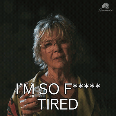 a woman holding a glass of wine with the words i 'm so f *** tired