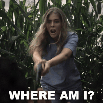 A Woman Holding A Gun In A Field With The Words Where Am I Below Her GIF