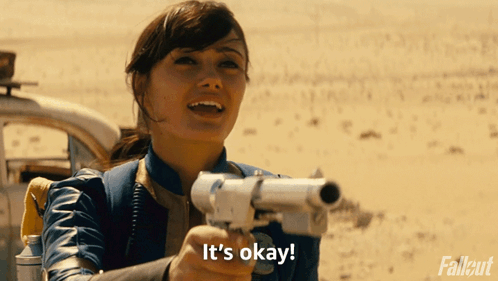 A Woman Holding A Gun With The Words It 'S Okay On The Bottom GIF