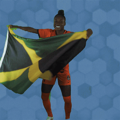 A Woman Holding A Jamaican Flag In Her Hands GIF