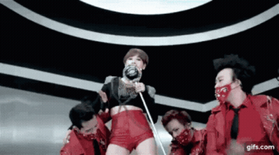 A Woman Holding A Lollipop Is Surrounded By A Group Of Men In Red GIF
