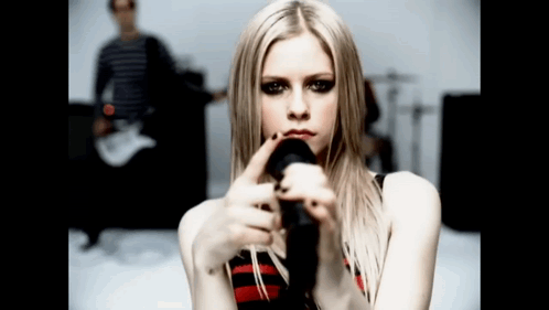 A Woman Holding A Microphone In Front Of Her Face GIF