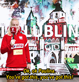 A Woman Holding A Microphone Standing In Front Of A Wall That Says Lublin GIF