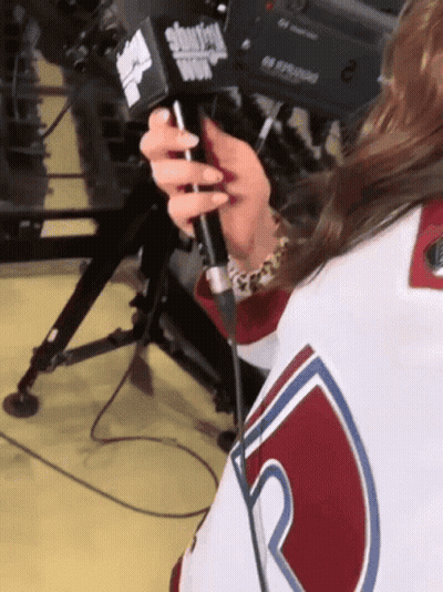 A Woman Holding A Microphone That Says Showtime GIF