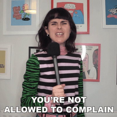 A Woman Holding A Microphone With The Words You 'Re Not Allowed To Complain Below Her GIF