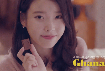 A Woman Holding A Piece Of Chocolate With The Word Ghana In Yellow GIF