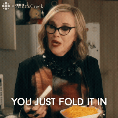 A Woman Holding A Plate Of Food With The Words You Just Fold It In GIF