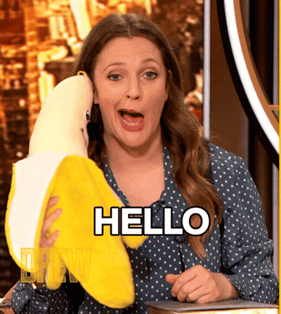 A Woman Holding A Stuffed Banana With The Word Hello Written On It GIF