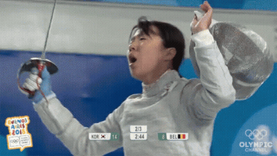 A Woman Holding A Sword In Front Of A Sign That Says " Olympic Channel " GIF