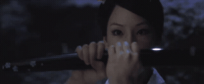A Woman Holding A Sword In Front Of Her Face GIF