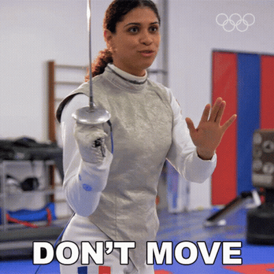 A Woman Holding A Sword With The Words " Don 'T Move " Above Her GIF
