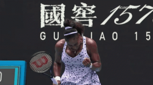 A Woman Holding A Tennis Racket In Front Of A Sign That Says Guiao 15 GIF