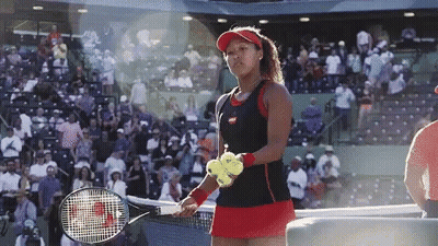 A Woman Holding A Tennis Racquet And A Tennis Ball GIF