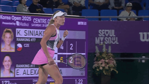 A Woman Holding A Tennis Racquet In Front Of A Seoul My Soul Sign GIF