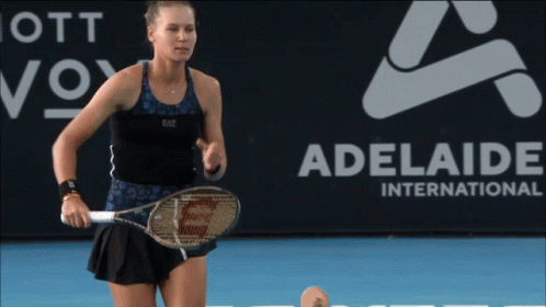 A Woman Holding A Tennis Racquet In Front Of An Adelaide International Sign GIF