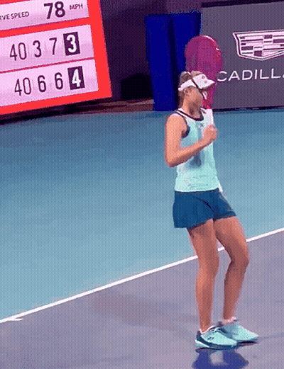 A Woman Holding A Tennis Racquet On A Tennis Court With A Cadillac Ad In The Background GIF