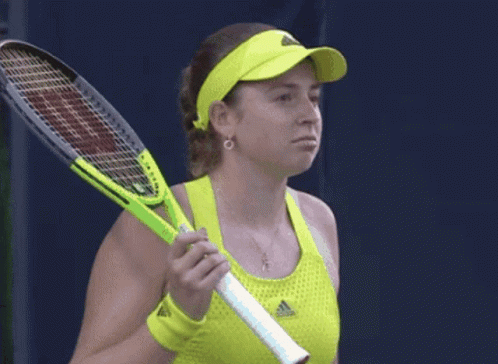 A Woman Holding A Tennis Racquet Wearing A Yellow Adidas Top GIF