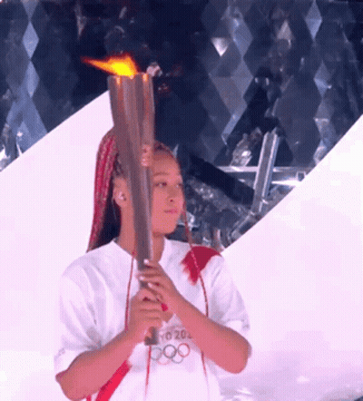 A Woman Holding A Torch That Says Tokyo 20 On It GIF
