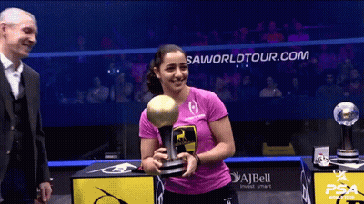 A Woman Holding A Trophy In Front Of A Sign That Says ' Saworldtour.com ' GIF
