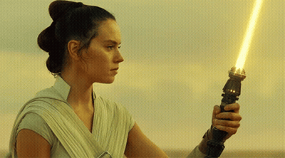 A Woman Holding A Yellow Light Saber In Her Hand GIF
