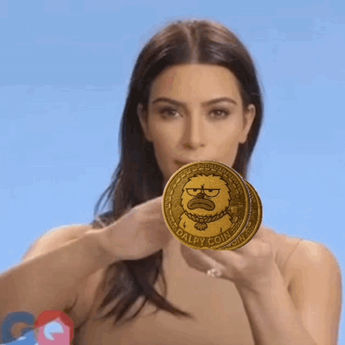 A Woman Holding Two Dalpy Coins In Front Of Her Face GIF