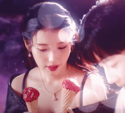 A Woman Holding Two Ice Cream Cones In Her Hand GIF