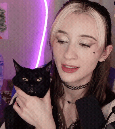 A Woman Holds A Black Cat In Her Arms GIF
