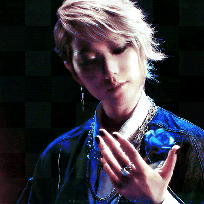 A Woman Holds A Blue Rose In Her Hand With A Ring On Her Left Hand GIF
