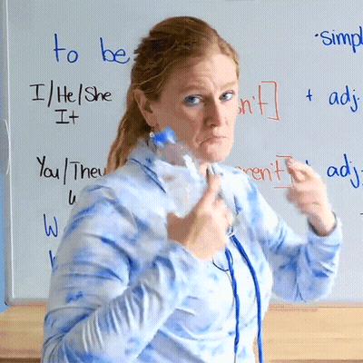 A Woman Holds A Bottle In Front Of A Whiteboard That Says To Be GIF