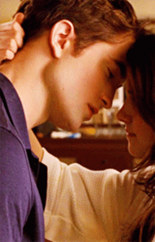 A Woman Holds A Man 'S Neck While They Look At Each Other GIF